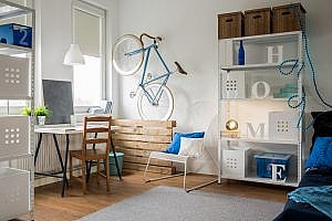 Comfortable small studio for young ideas man with bike on wall and funky furniture