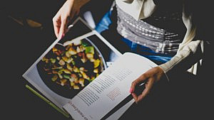 A lady reading a cook book 