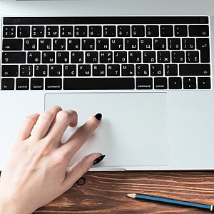 a hand using a laptop - keyboard
