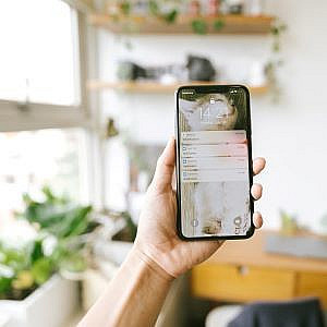 a phone held up in front of a shelf in a virtual organising session
