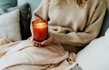 Dec-2025-blog-cosying-down-with-hygge-lady-with-candle.png