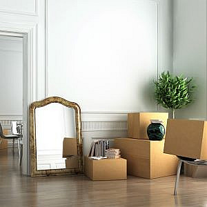 a room filled with packing boxes and a mirror standing against the wall