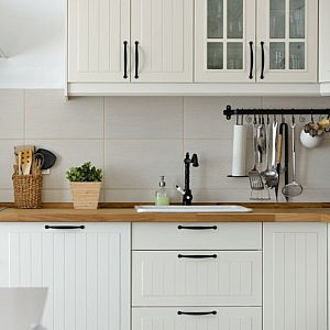 a tidy organised decluttered kitchen counter with white cupboards
