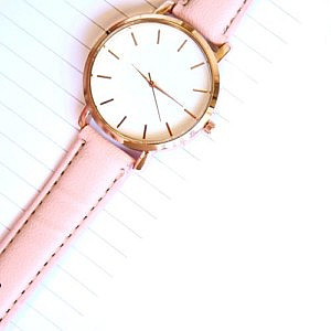 a watch laid across a productivity notepad