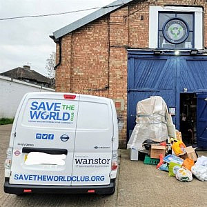 The Save The World Club van outside the depot with bags of donations